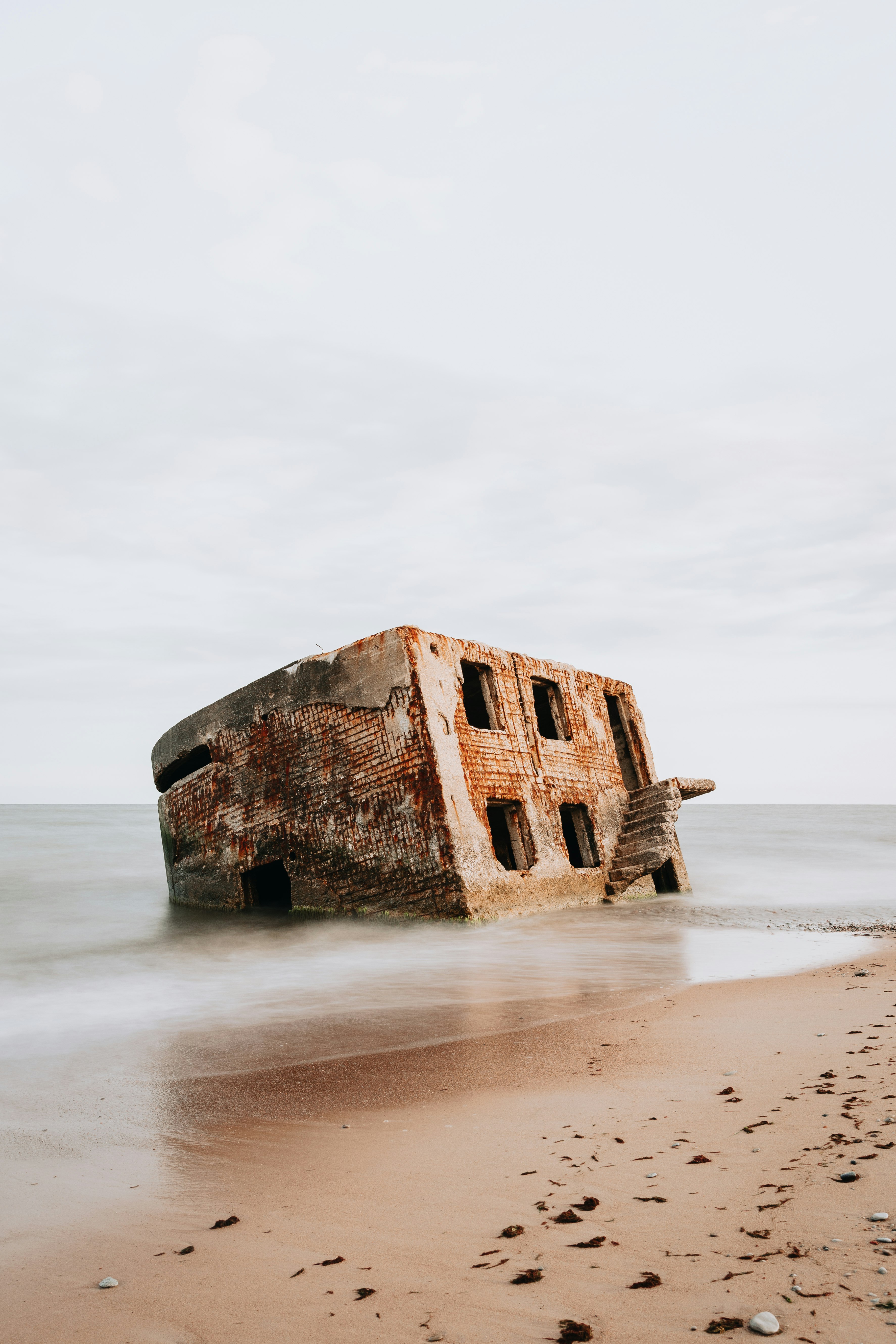 brown concrete building on white sand beach during daytime